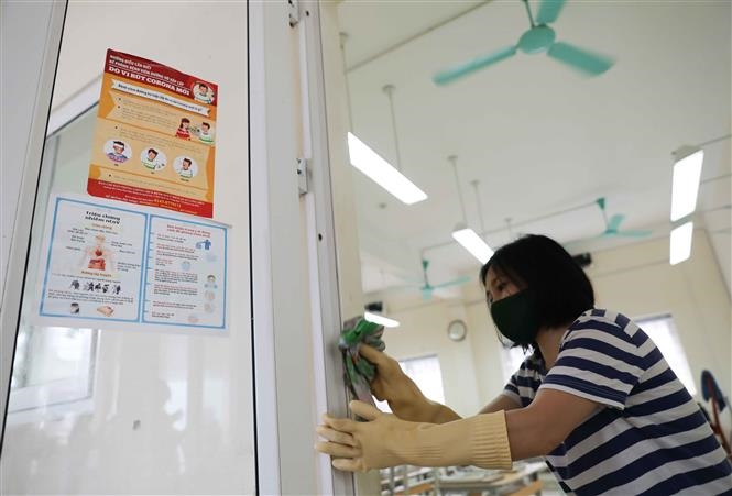  Trong ảnh: Nhân viên y tế Trường THPT Nguyễn Gia Thiều, quận Long Biên hướng dẫn giáo viên sử dụng thiết bị đo thân nhiệt đúng cách. Ảnh: Thanh Tùng - TTXVN  Trong ảnh: Trường THPT Nguyễn Gia Thiều, quận Long Biên hoàn thành vệ sinh, khử khuẩn và các công tác chuẩn bị khác, sẵn sàng đón học sinh trở lại trường từ 4/5. Ảnh: Thanh Tùng - TTXVN