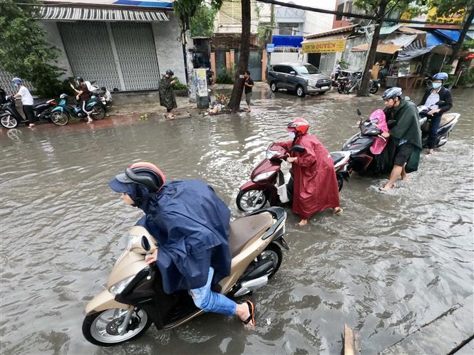 Trong ảnh: Nước ngập cao khiến hàng loạt phương tiện bị chết máy phải dẫn bộ. Ảnh: TTXVN phát.