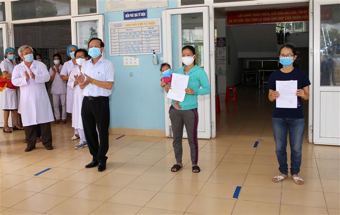  Lãnh đạo Sở Y tế Quảng Trị trao giấy xác nhận hoàn thành thời gian cách ly y tế phòng, chống dịch COVID-19 cho 2 bệnh nhân. Ảnh: Hồ Cầu-TTXVN