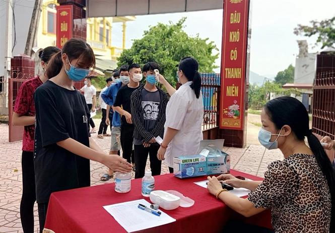 Thí sinh được đo thân nhiệt, rửa tay sát khuẩn trước khi vào làm thủ tục dự thi. Ảnh: Xuân Thỏa-TTXVN phát