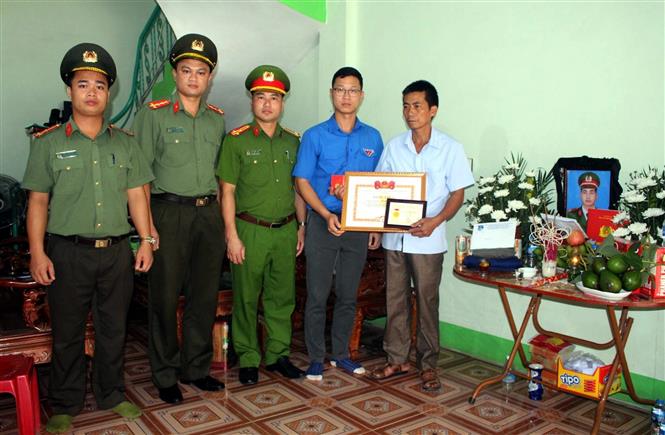 Đồng chí Thân Trung Kiên - Bí thư Tỉnh đoàn, Chủ tịch Hội LHTN tỉnh Bắc Giang truy tặng huy hiệu “Tuổi trẻ dũng cảm" của Trung ương Đoàn cho chiến sỹ công an nghĩa vụ Nguyễn Văn Mạnh hi sinh khi làm nhiệm vụ. Ảnh: Đồng Thúy - TTXVN