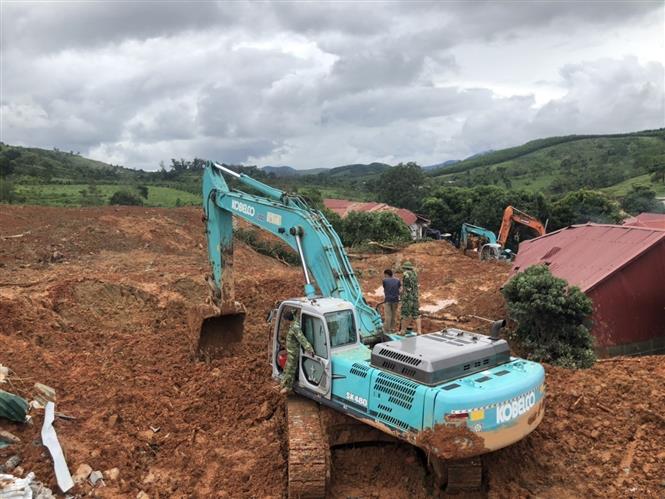 Phương tiện cơ giới khẩn trương đào bới tìm kiếm người bị vùi lấp. Ảnh: TTXVN phát